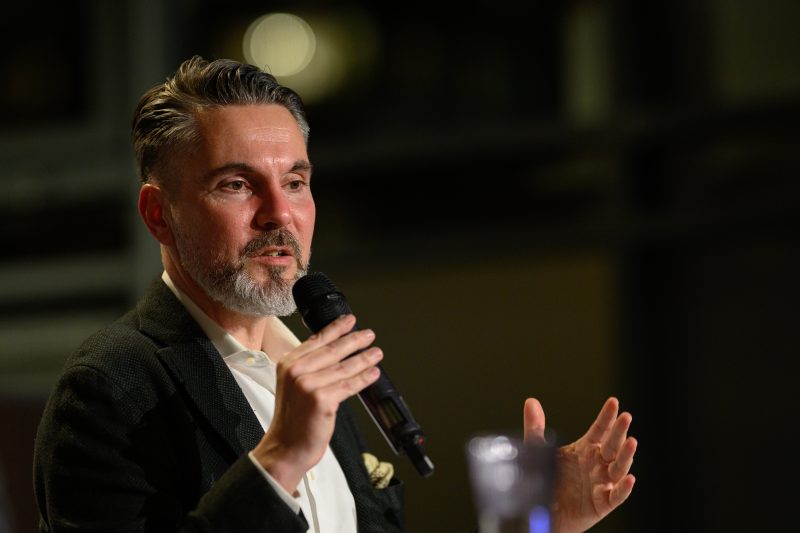 Man speaking into microphone at an event © Dirk Heurich dirksn.com