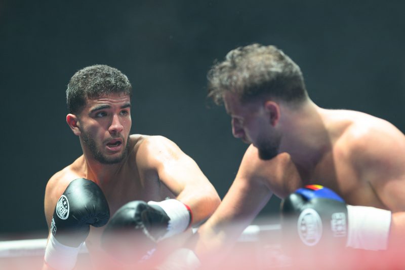 Boxers mid-fight in intense boxing match © Dirk Heurich dirksn.com