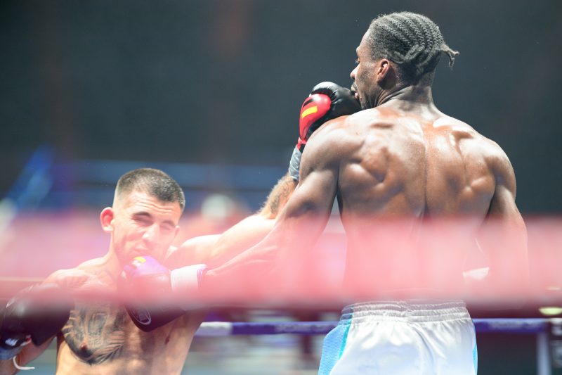 Boxers mid-fight in intense boxing match © Dirk Heurich dirksn.com