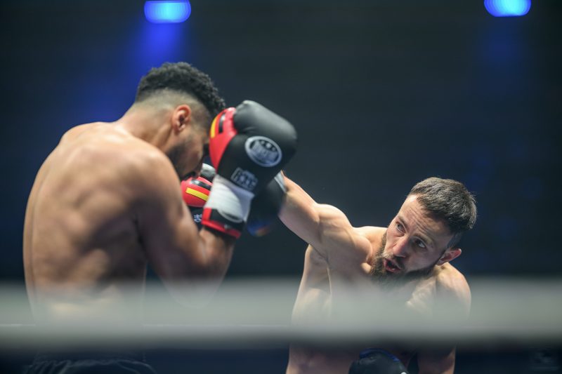 Boxers mid-fight in intense boxing match © Dirk Heurich dirksn.com